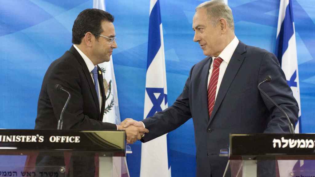 Jimmy Morales, presidente de Guatemala (i), estrecha la mano de Netanyahu (d), primer ministro israelí.