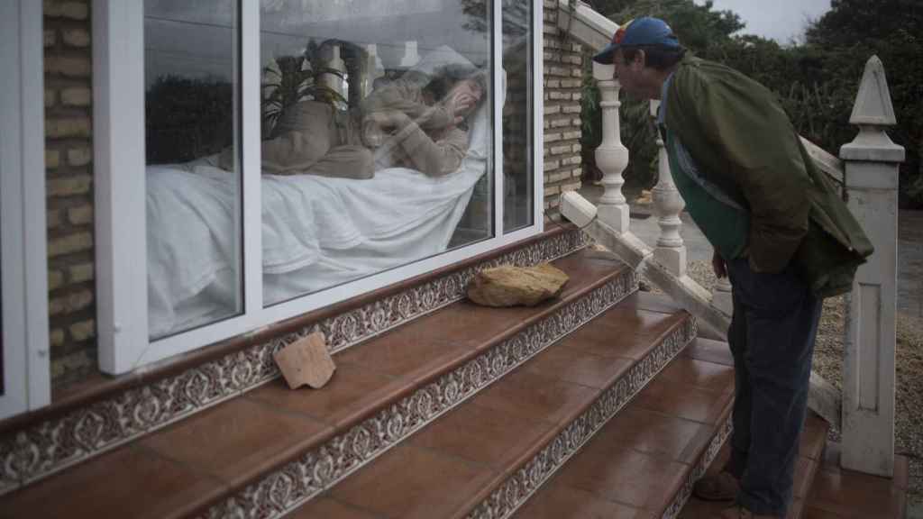 Juana, junto al ventanal, ante la mirada de su marido Manuel.