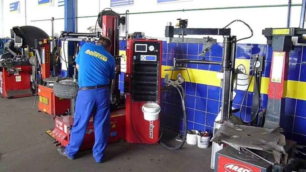 Fotografía de un mecánico del taller de Mérida revisando ruedas, tomada en 2014